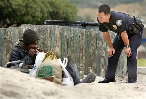 homeless on beach with cop 300x204 Crimes of homelessness: Dealing with a legal system ill equipped to make an impact 